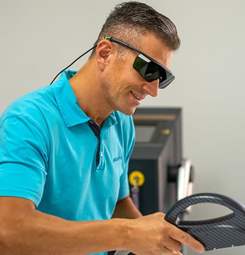 Ein Mann mit Sonnenbrille benutzt ein Gerät für IPL- und Lasertechnologie, um unerwünschte Körperhaare zu entfernen.